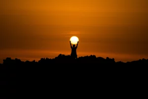 A person standing atop a hill, arms outstretched, savoring the breathtaking vista