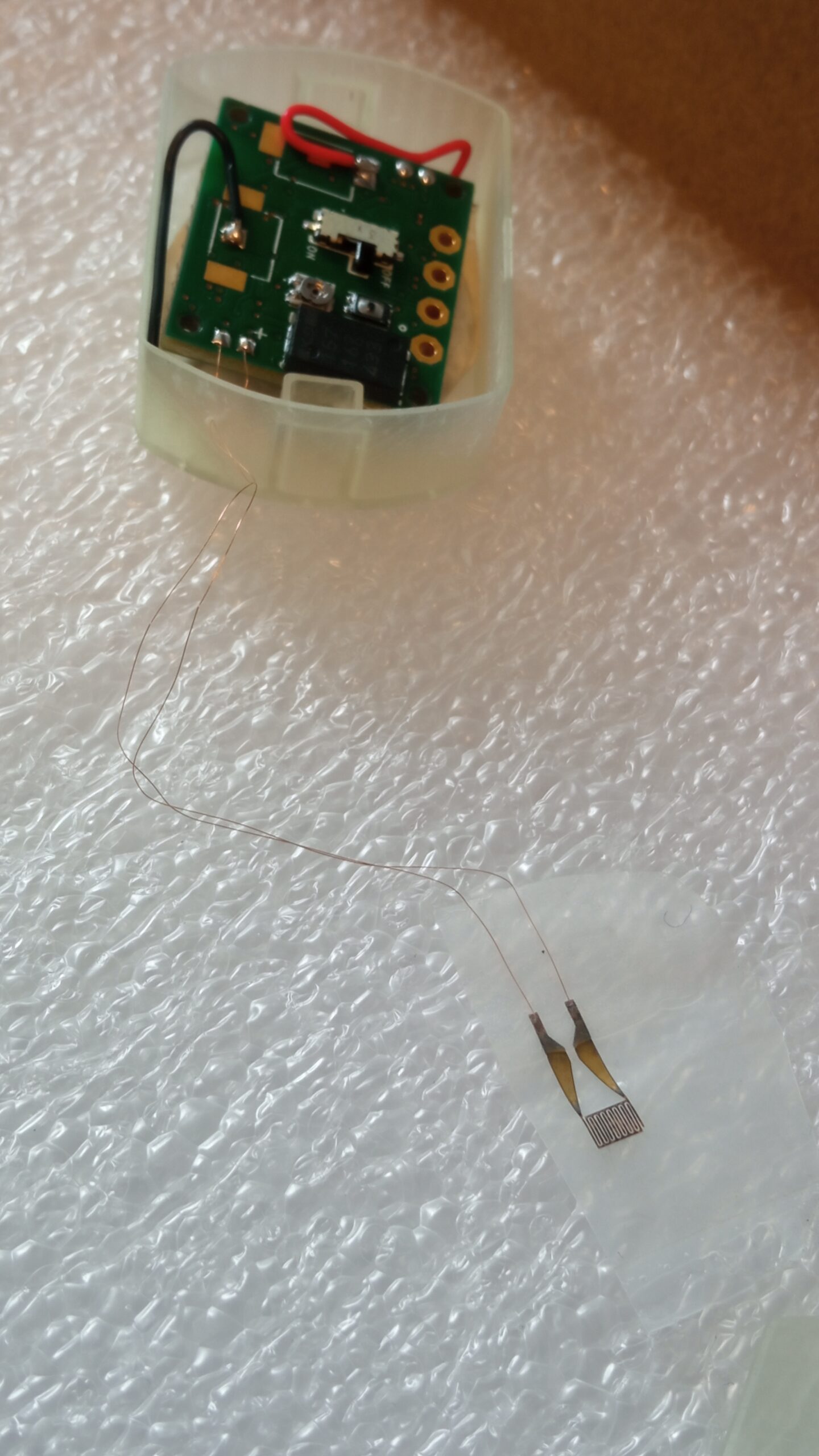 A close-up of the innovative RISEUP technology, featuring an ultra-flexible and miniaturized electrode connected to a battery, enabling wireless stimulation. This groundbreaking system represents a major advancement in neurostimulation technology.