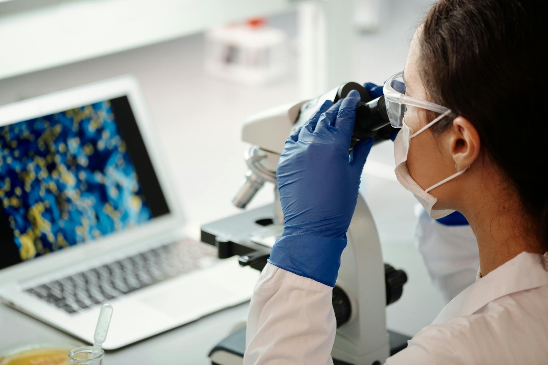 Close-up Photo of Medical Professional using Microscope